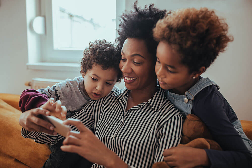 smiling family looking at phone